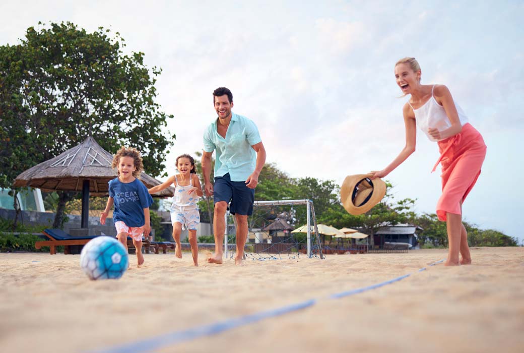 Family playing on the beach at Conrad Bali