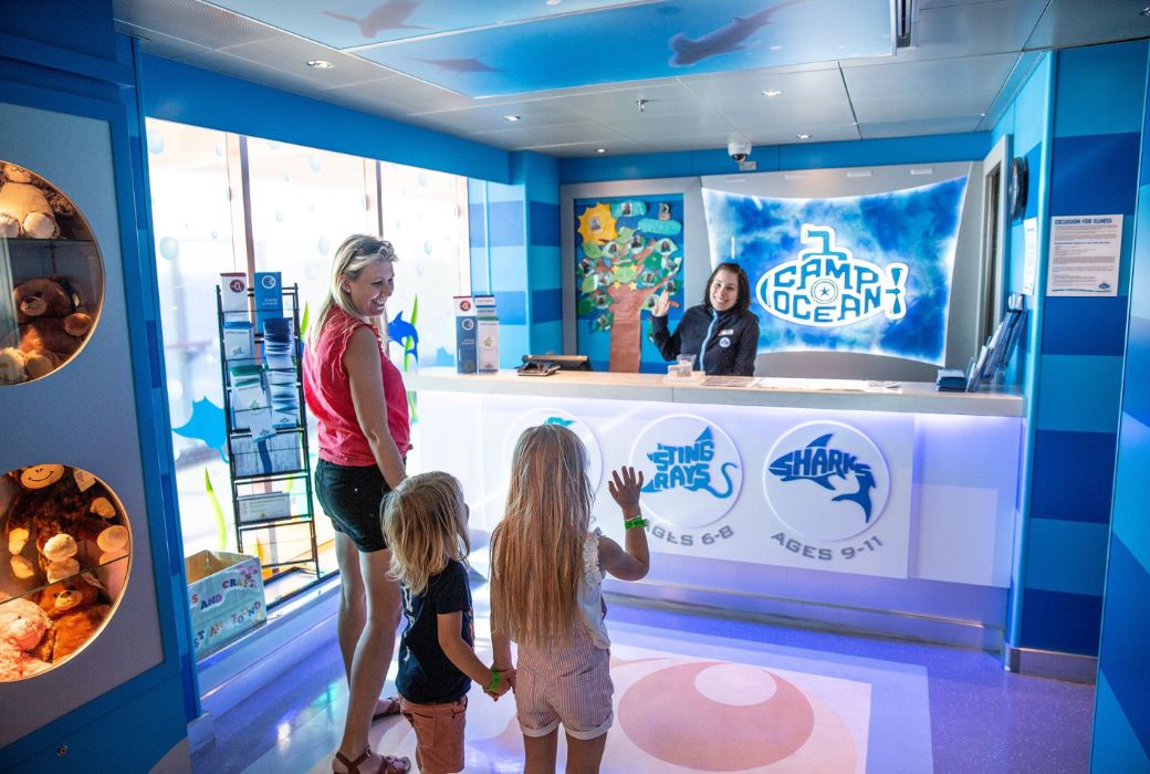 Kids wave at a girl behind a counter
