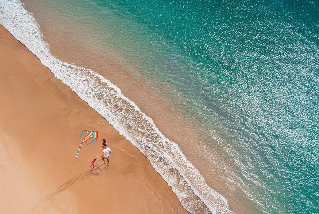 family flying kites on beach at InterContinental Bali Resort