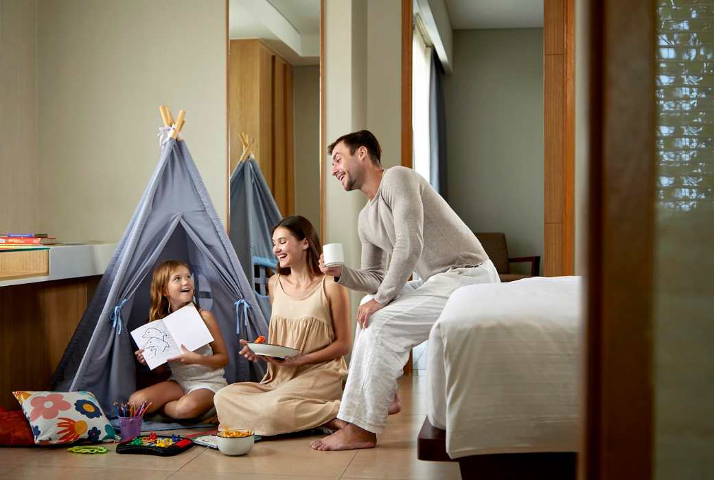 a family sitting inside a hotel room