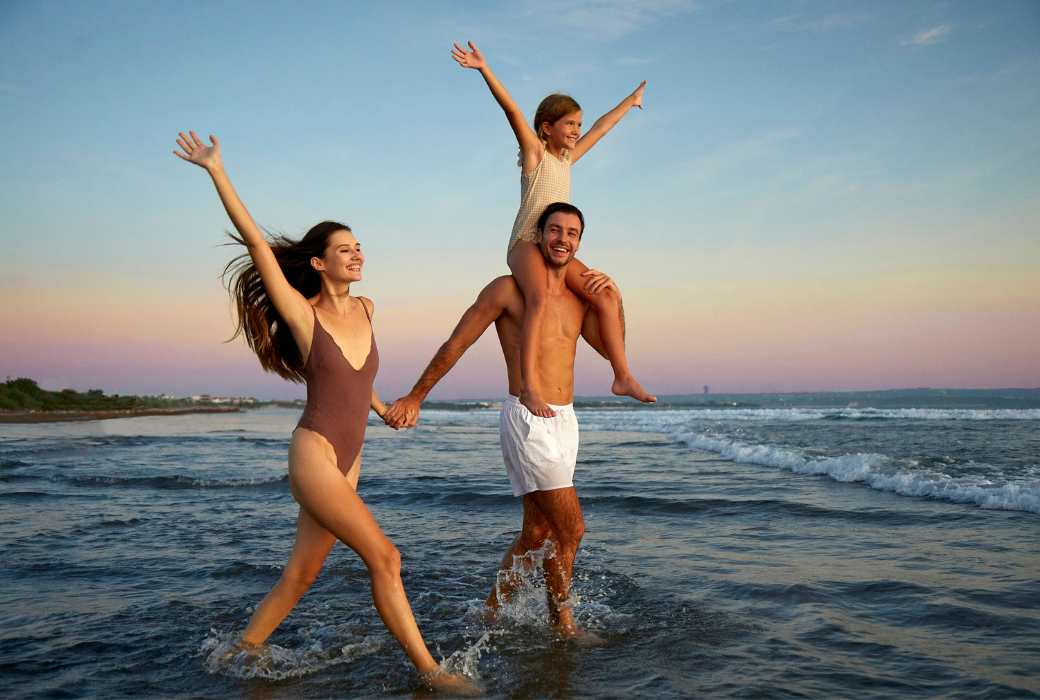 a family splashing in the waves at the beach