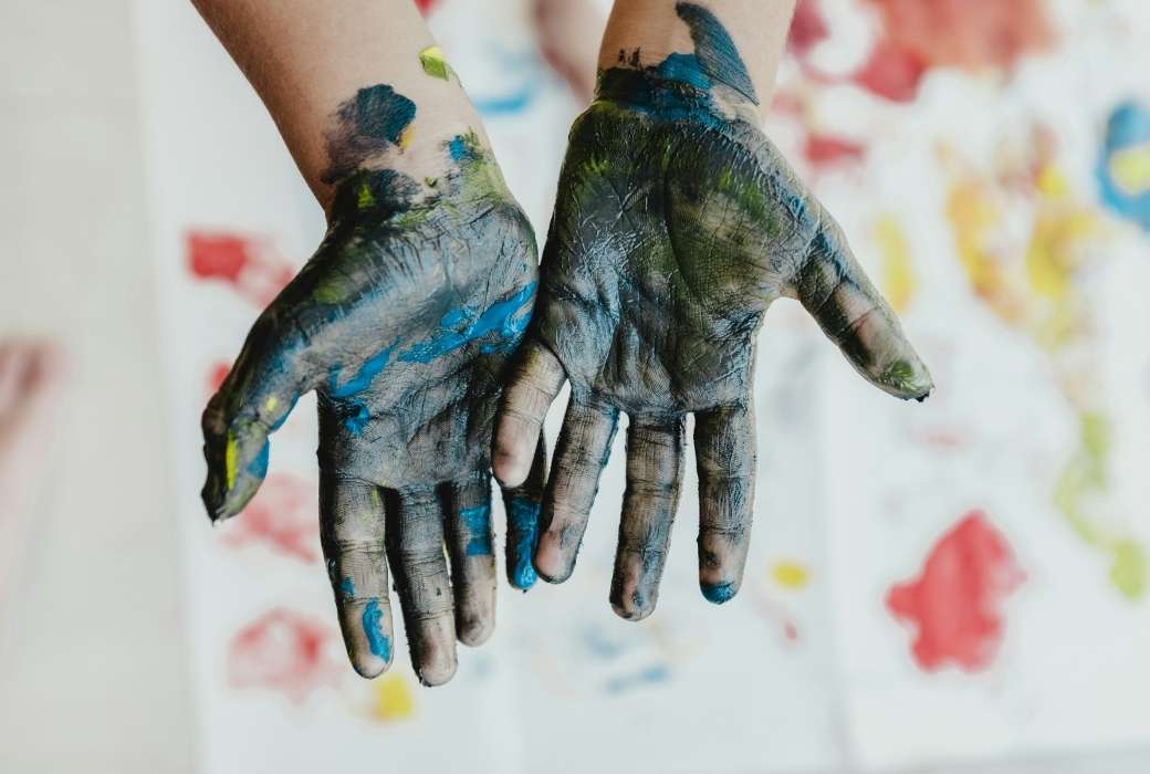 A child's hand covered in blue paint