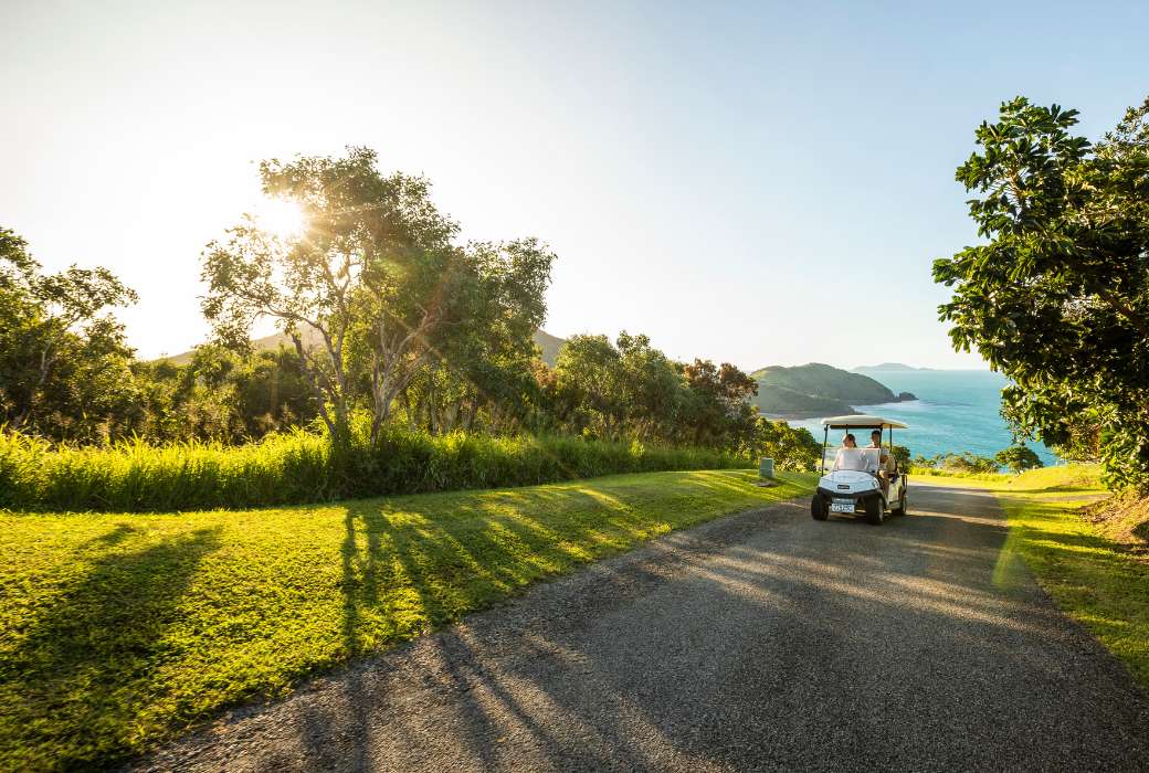 A couple exploring Keswick Island in a golf cart