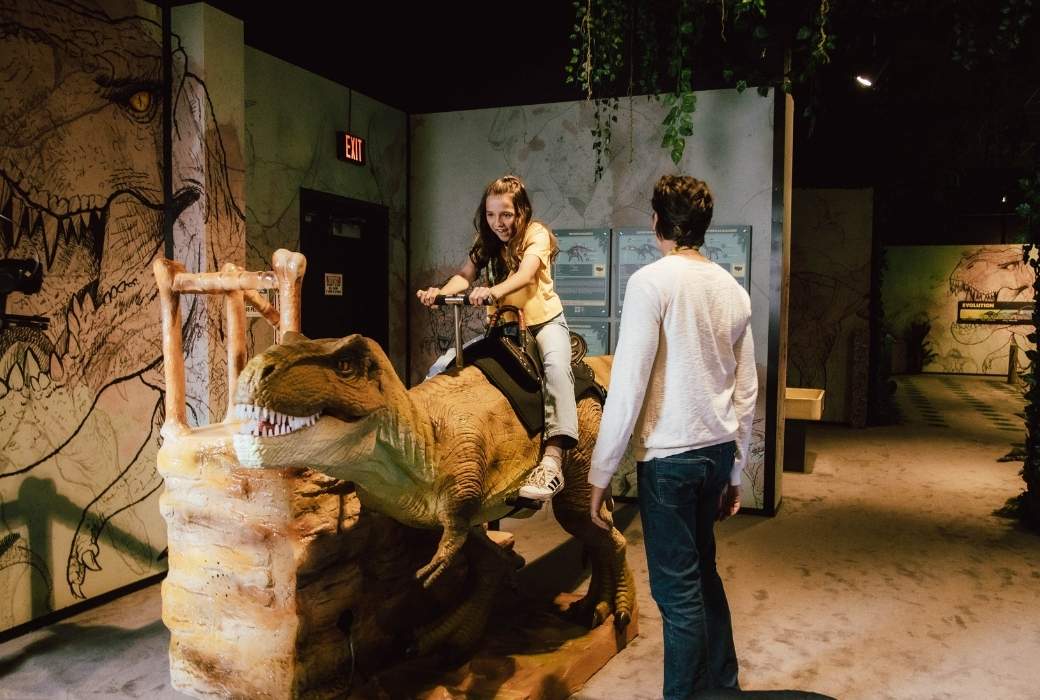 child riding an animatronic dinosaur